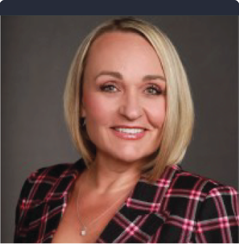 A woman in a plaid jacket is smiling for the camera