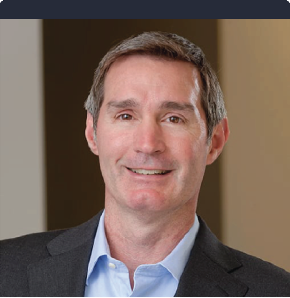 A man in a suit and blue shirt smiles for the camera