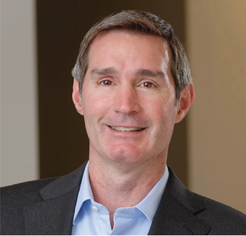 A man in a suit and blue shirt smiles for the camera