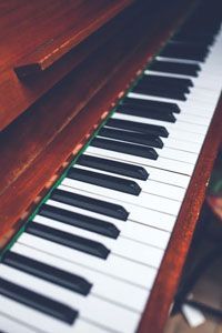A close-up, angled view of wooden piano keys with alternating black and white keys.