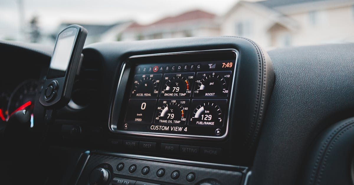 A close up of a car dashboard with a radio and a cell phone holder.  | Automotive Express