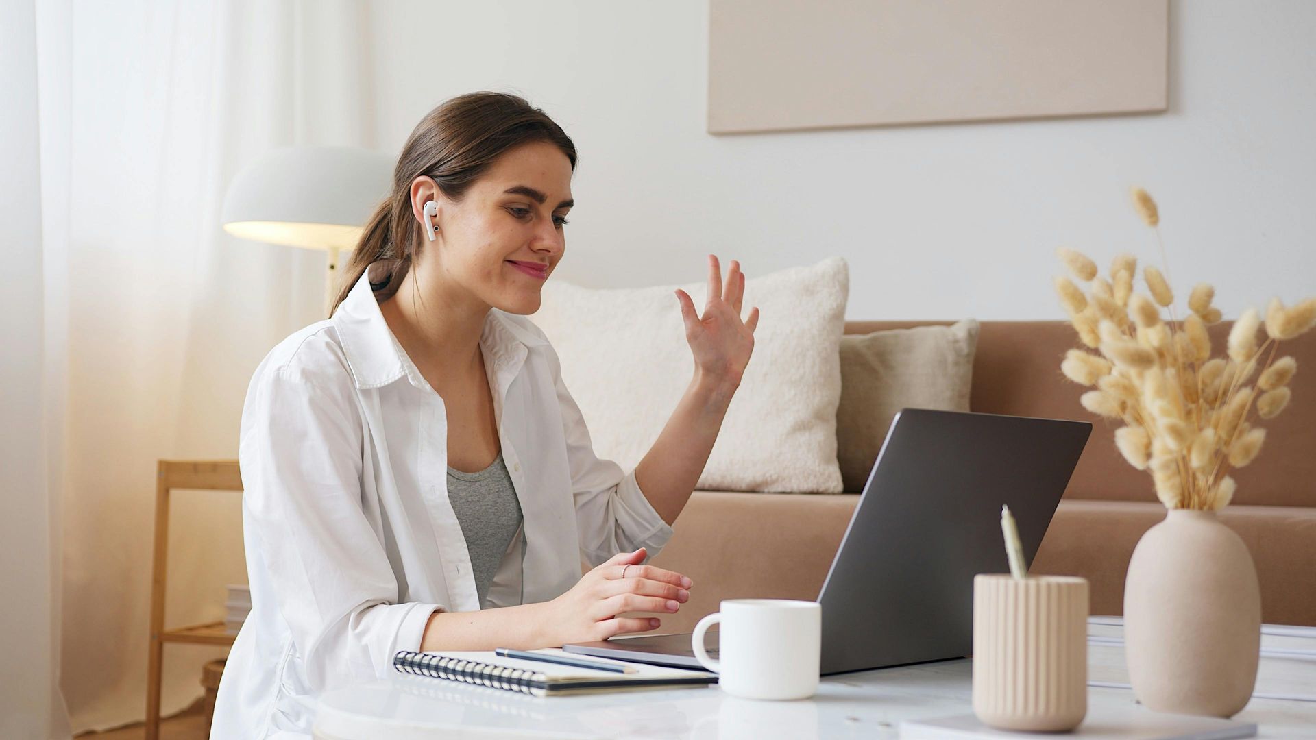 A woman is sitting at a table using a laptop computer.