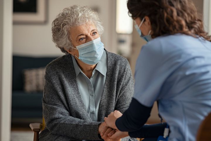 Female Doctor Consoling Senior Woman Wearing Face Mask - Monroe, NC - Neighborhood Nurses