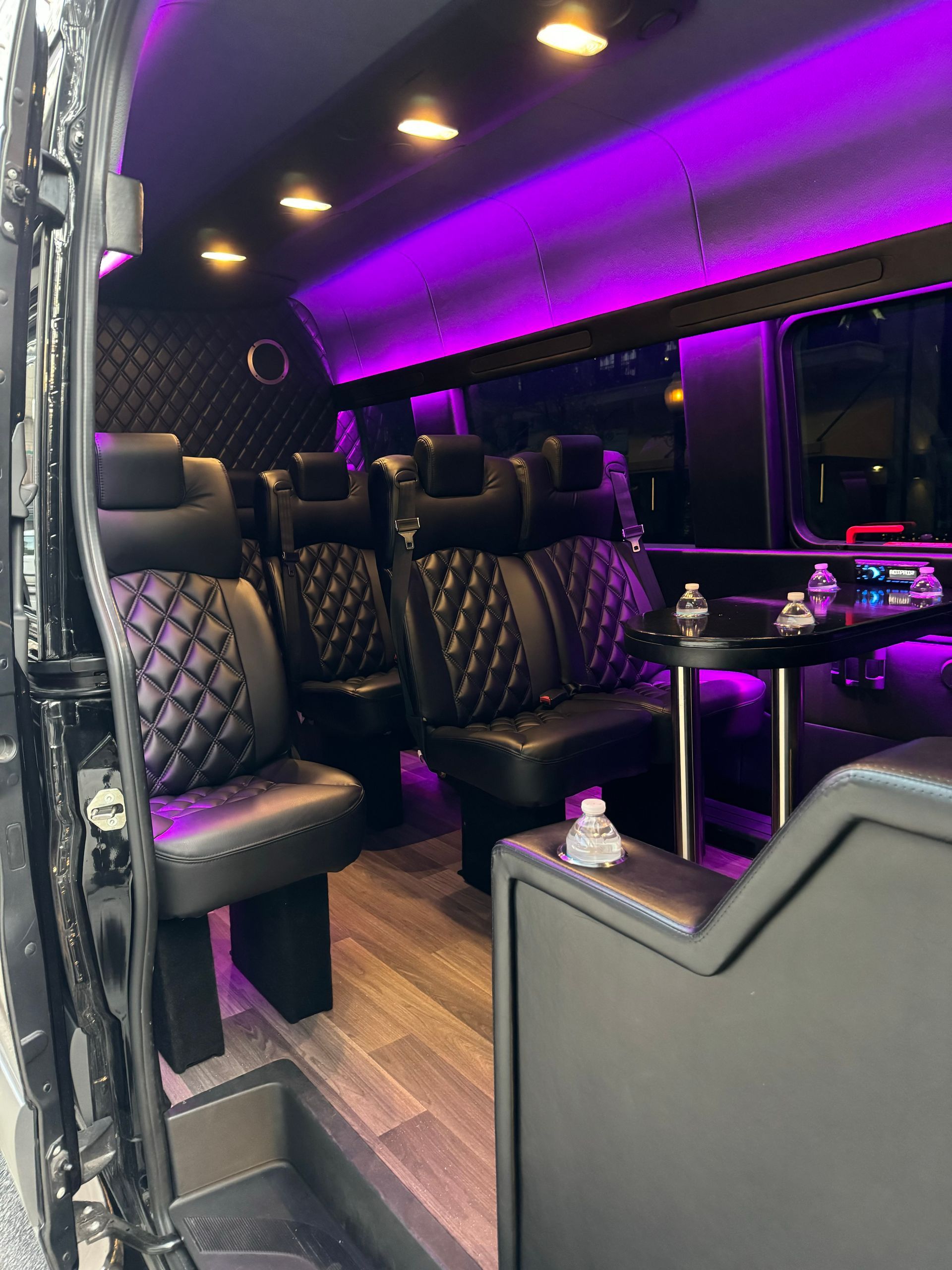 The inside of a van with purple lights and tables.