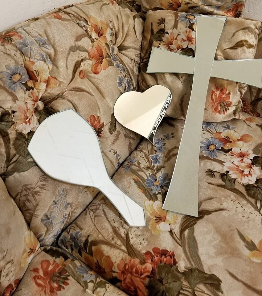 A cross and a mirror are on a floral couch