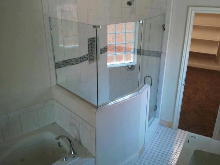 A bathroom with a tub and a shower with a glass door