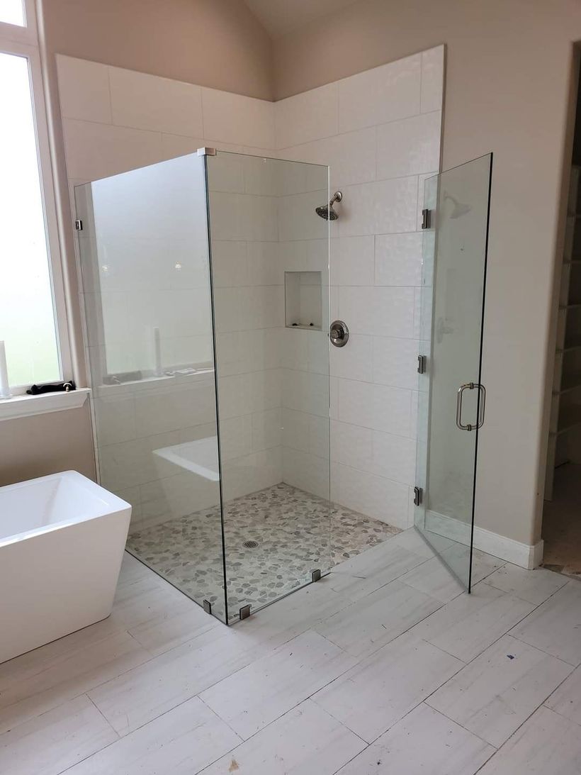 A bathroom with two sinks and a walk in shower.