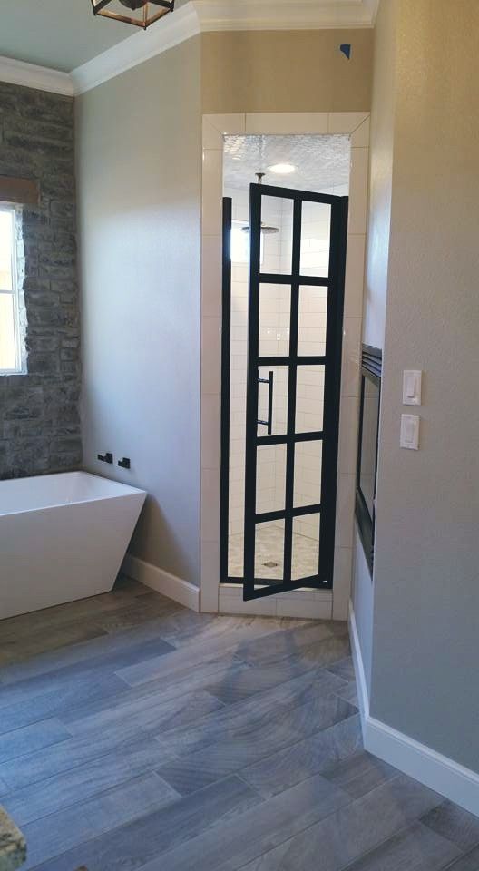 A bathroom with a bathtub and a shower door.