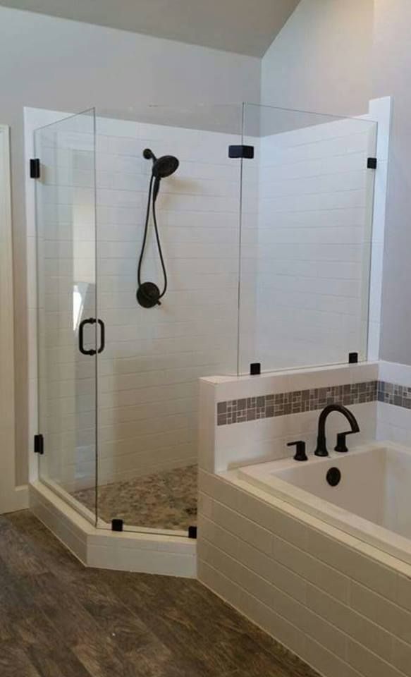 A bathroom with a tub and a shower with a glass door.