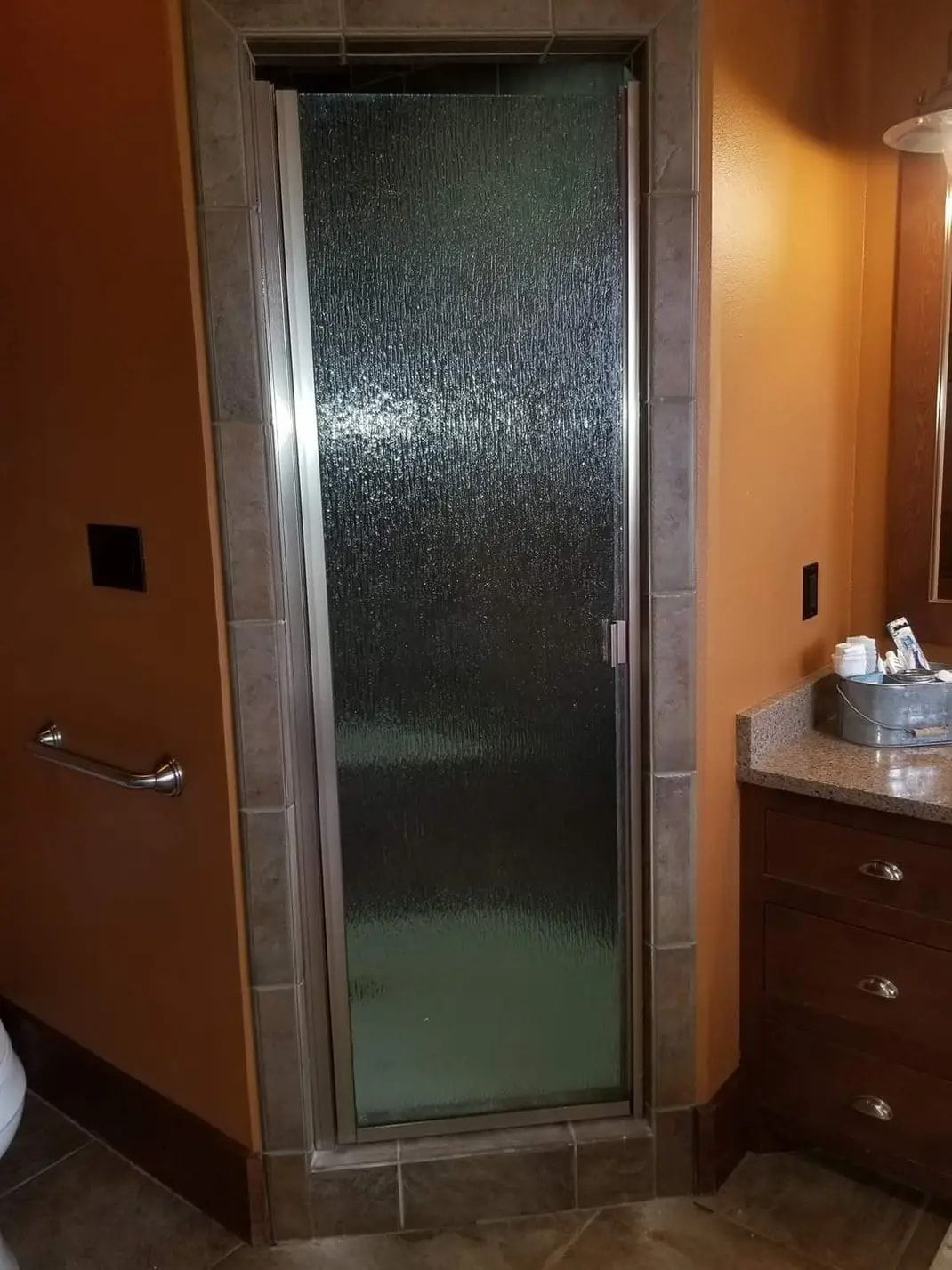 A bathroom with a walk in shower and a sink.