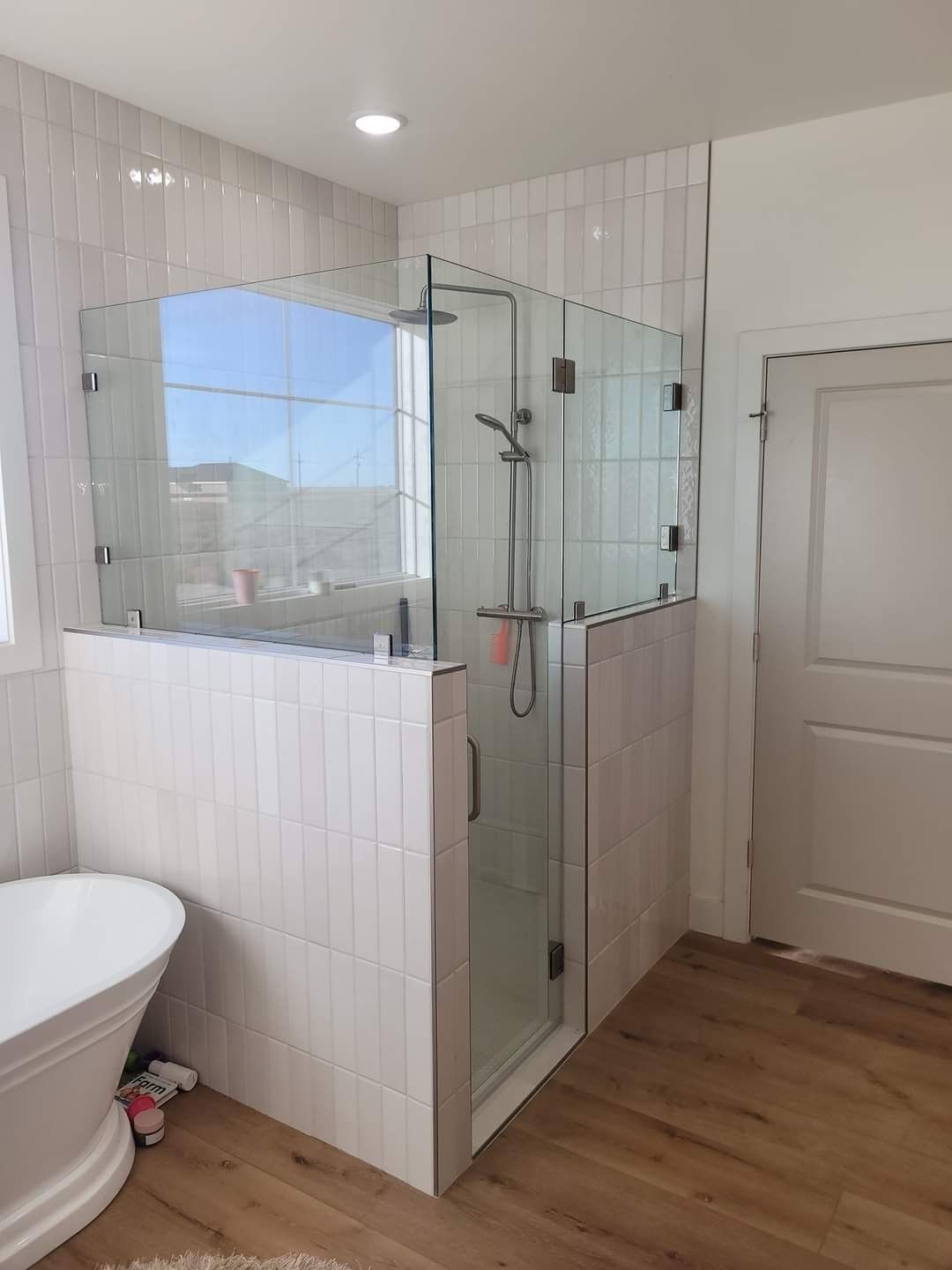 A bathroom with a walk in shower and a tub.
