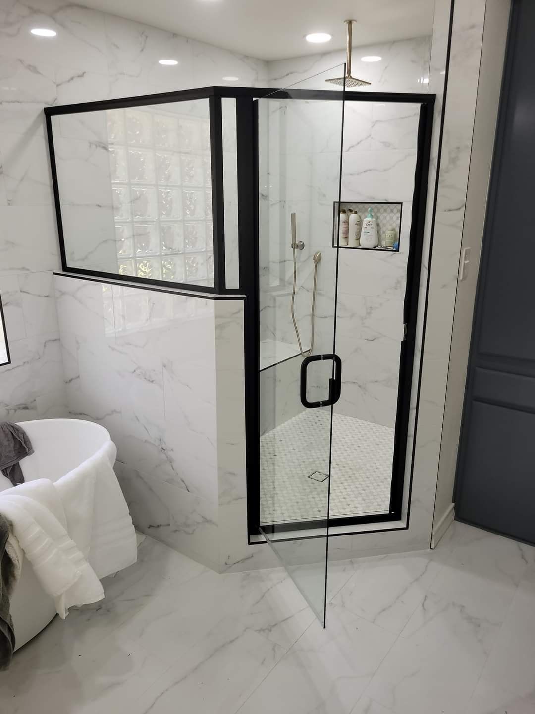 A bathroom with a walk in shower and a bathtub.