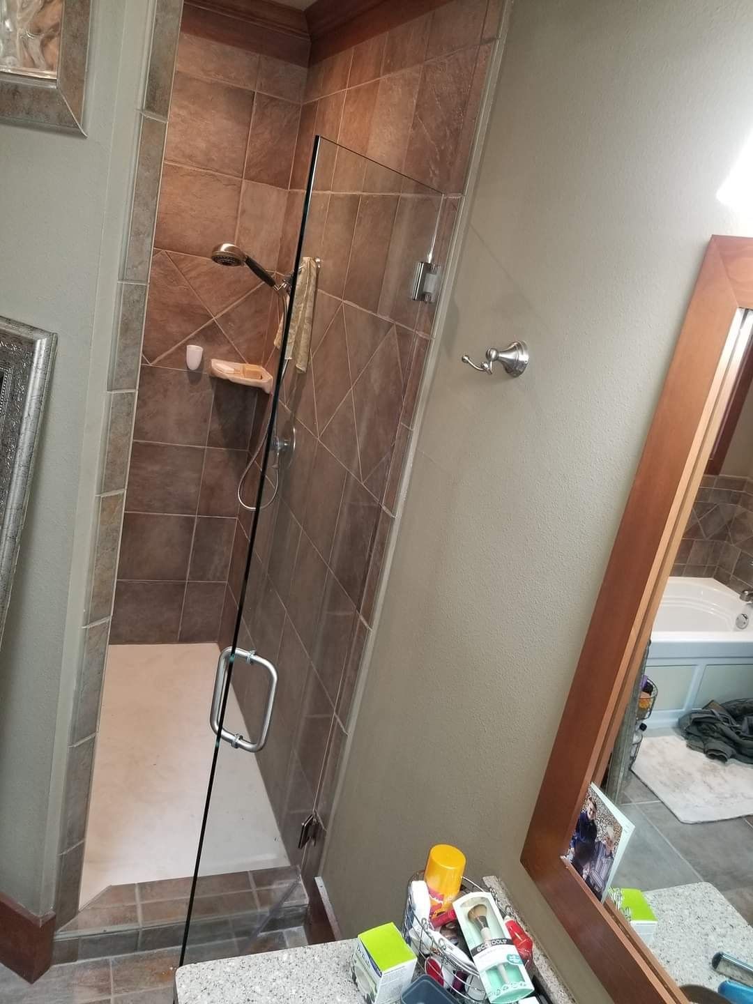 A bathroom with a walk in shower and a mirror.