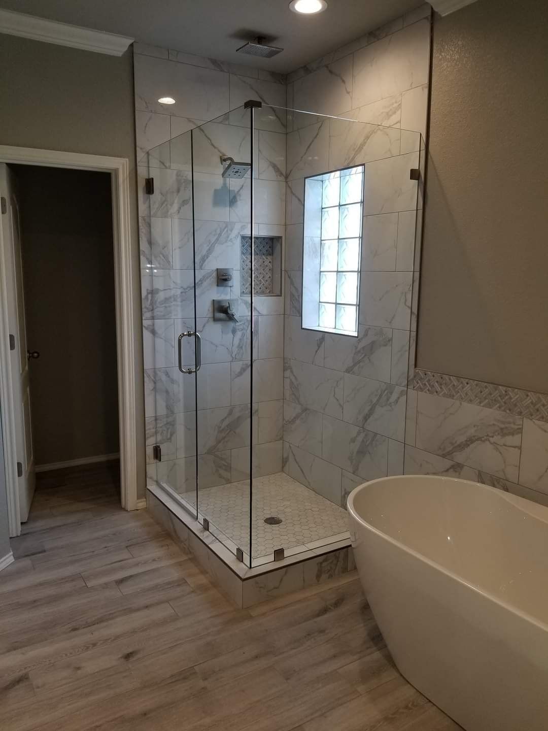 A bathroom with a walk in shower and a bathtub.