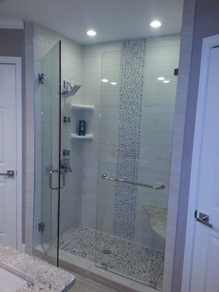 A bathroom with a walk in shower with a glass door.