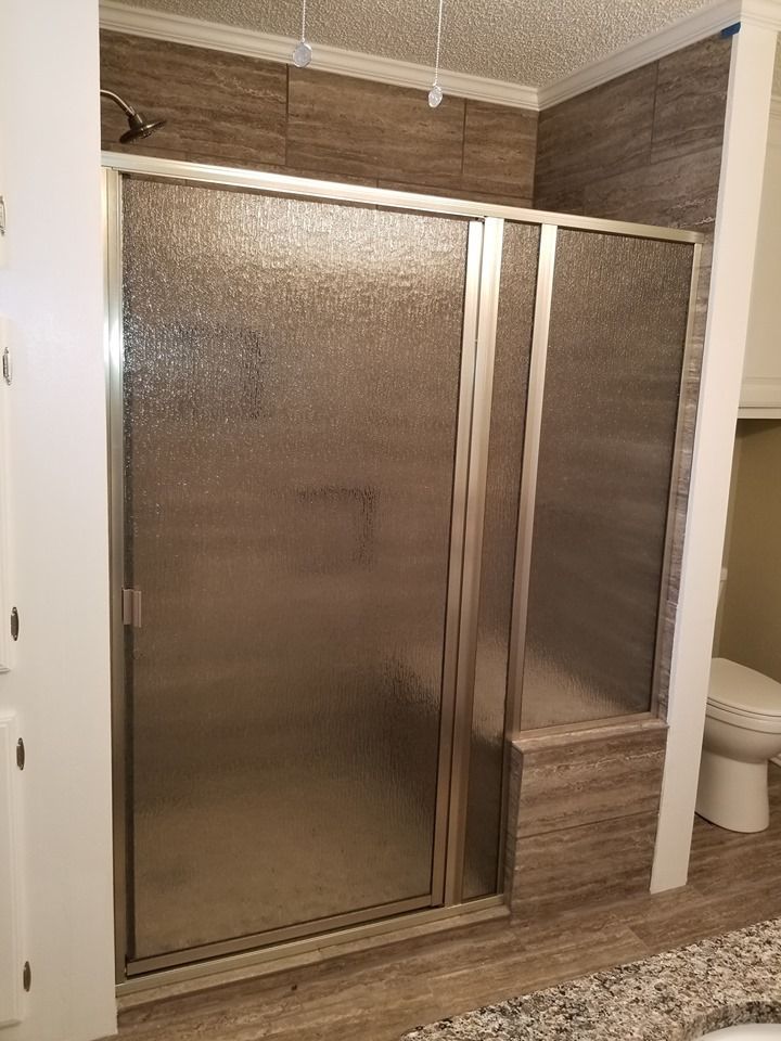 A bathroom with a walk in shower and a toilet.