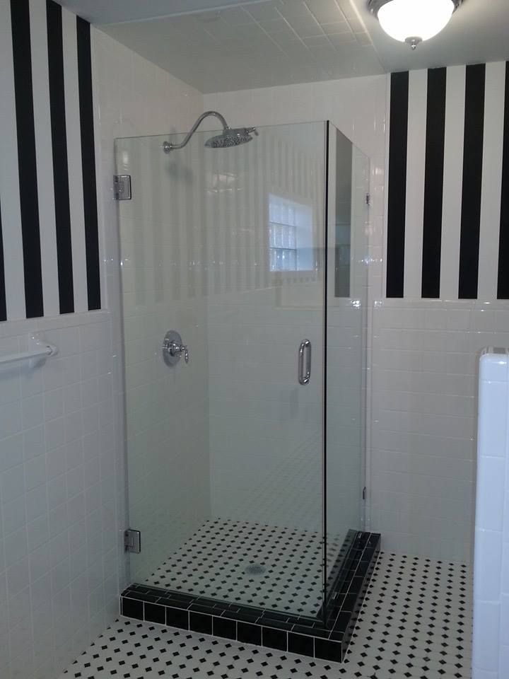 A bathroom with black and white stripes and a walk in shower