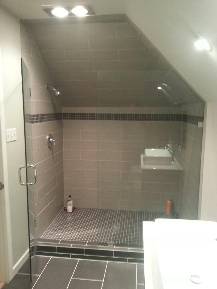 A bathroom with a walk in shower and a sink