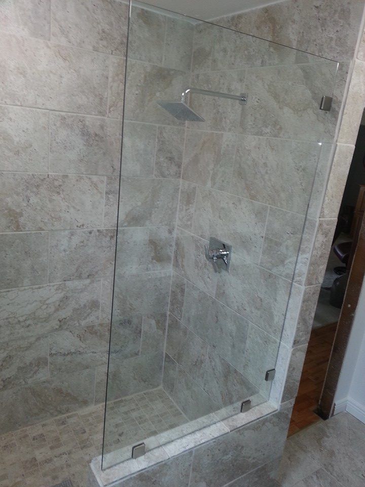 A bathroom with a glass shower door and a shower head.