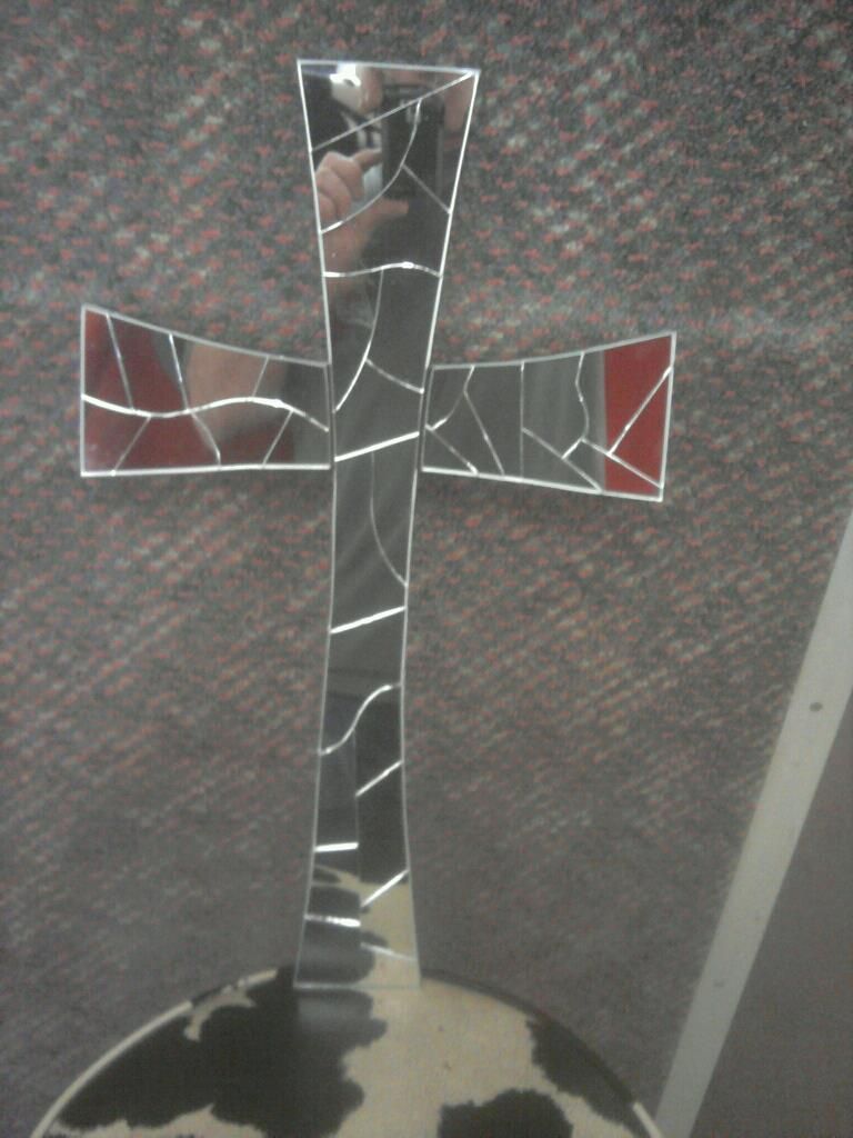 A stained glass cross is sitting on top of a globe