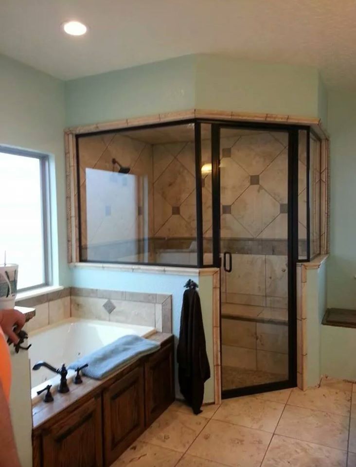 A bathroom with a tub and a shower with a glass door