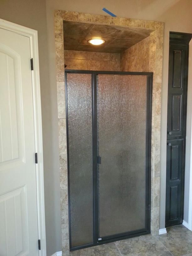 A bathroom with a sliding glass shower door