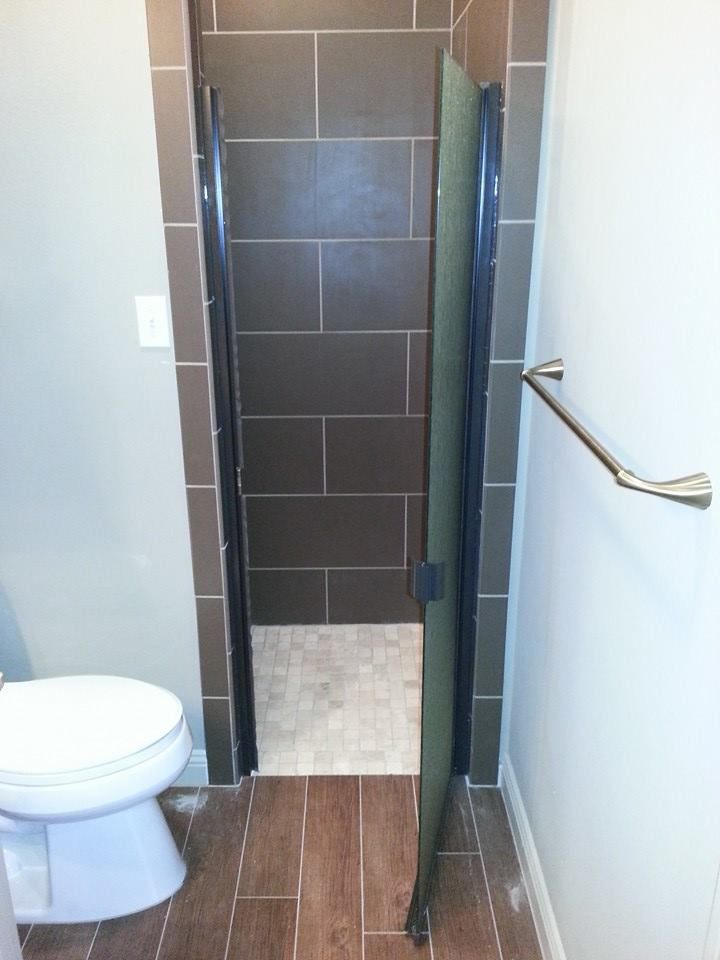 A bathroom with a toilet and a walk in shower