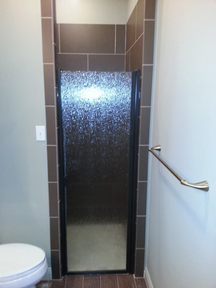 A bathroom with a toilet and a walk in shower