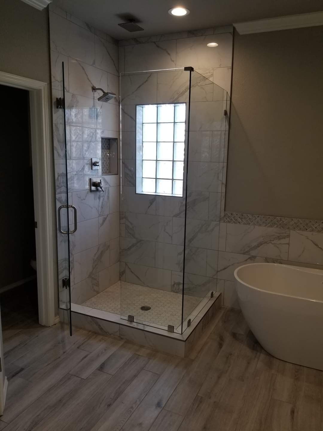 A bathroom with a walk in shower and a bathtub.