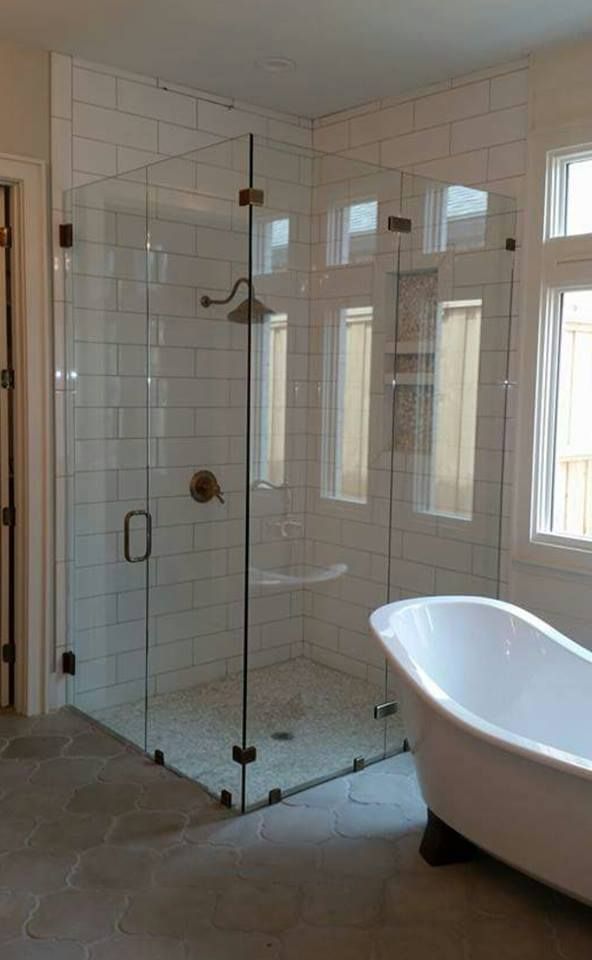 A bathroom with a bathtub and a shower with a glass door.