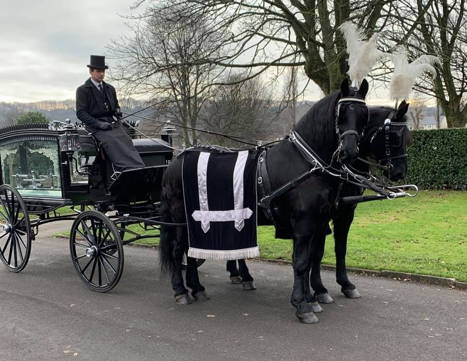 A man is riding a horse drawn carriage.