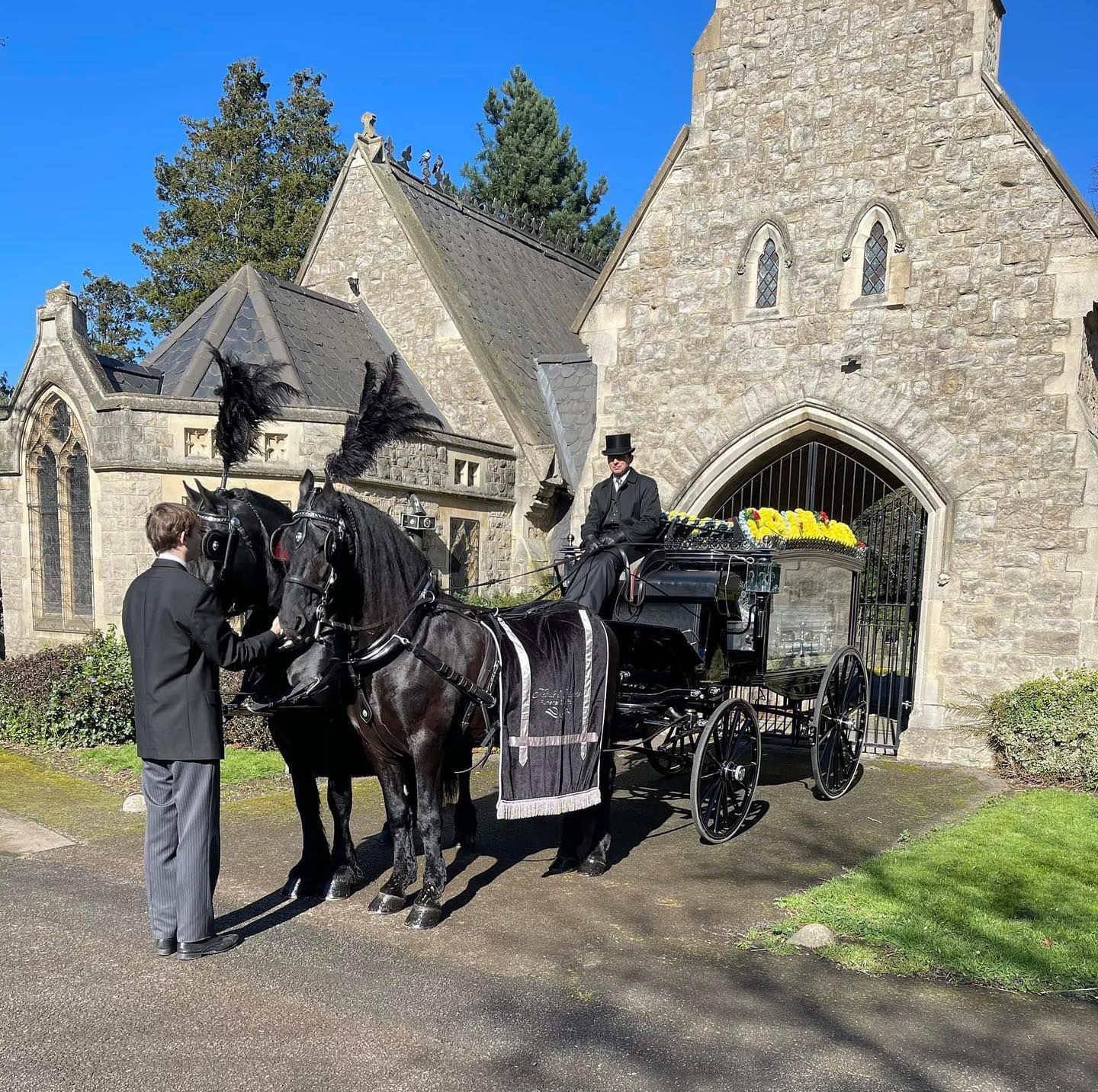 A horse drawn carriage is parked in front of a church