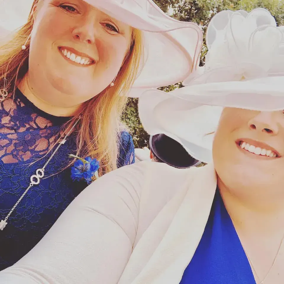 Two women wearing hats and smiling for a picture