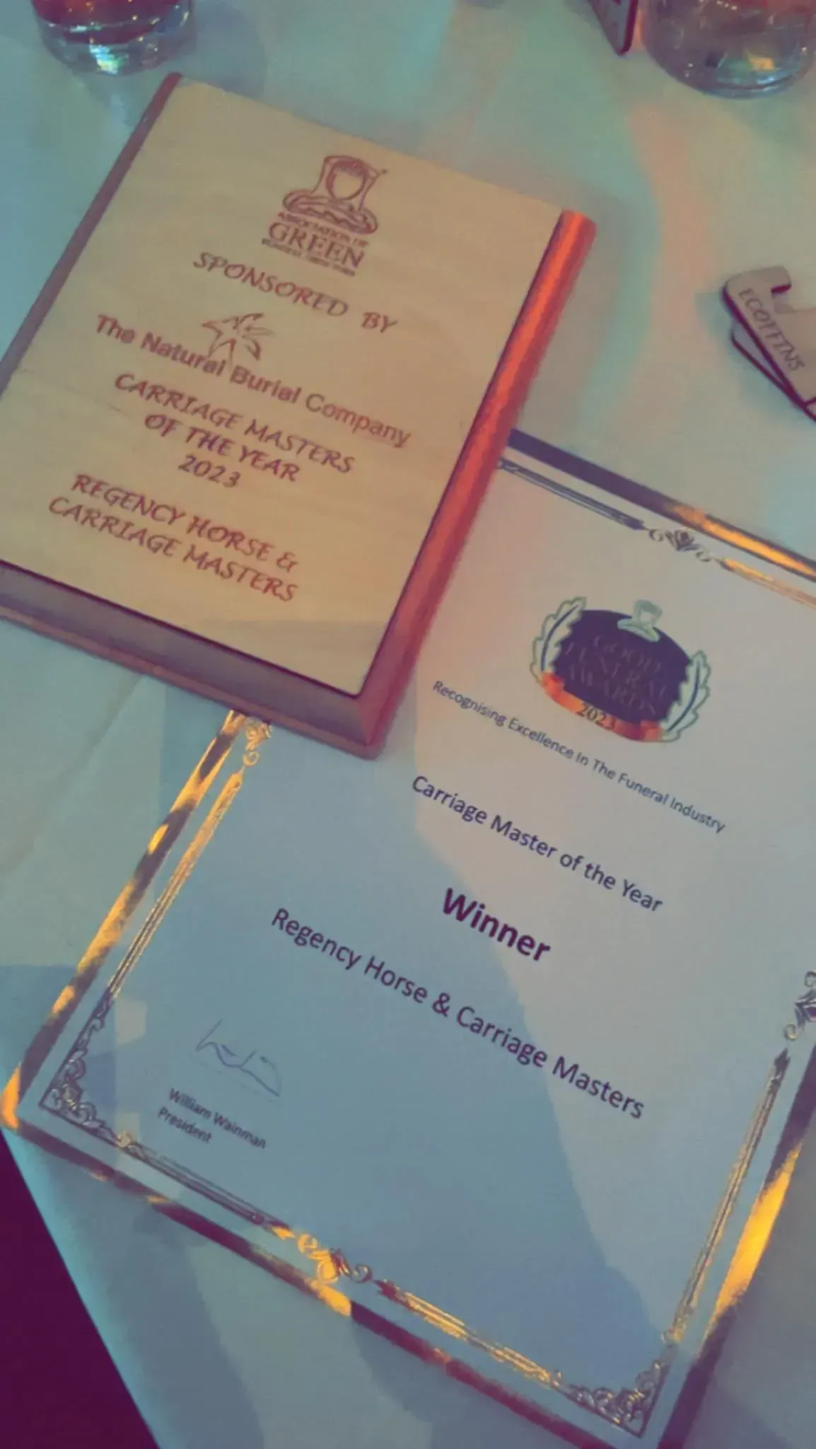 Two awards on a table one of which is a winner