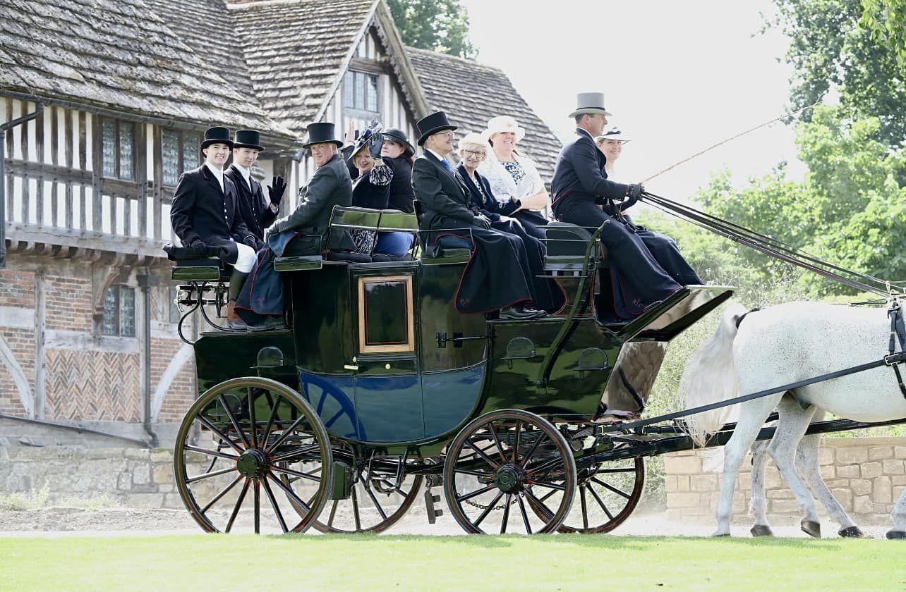 A group of people are riding in a horse drawn carriage
