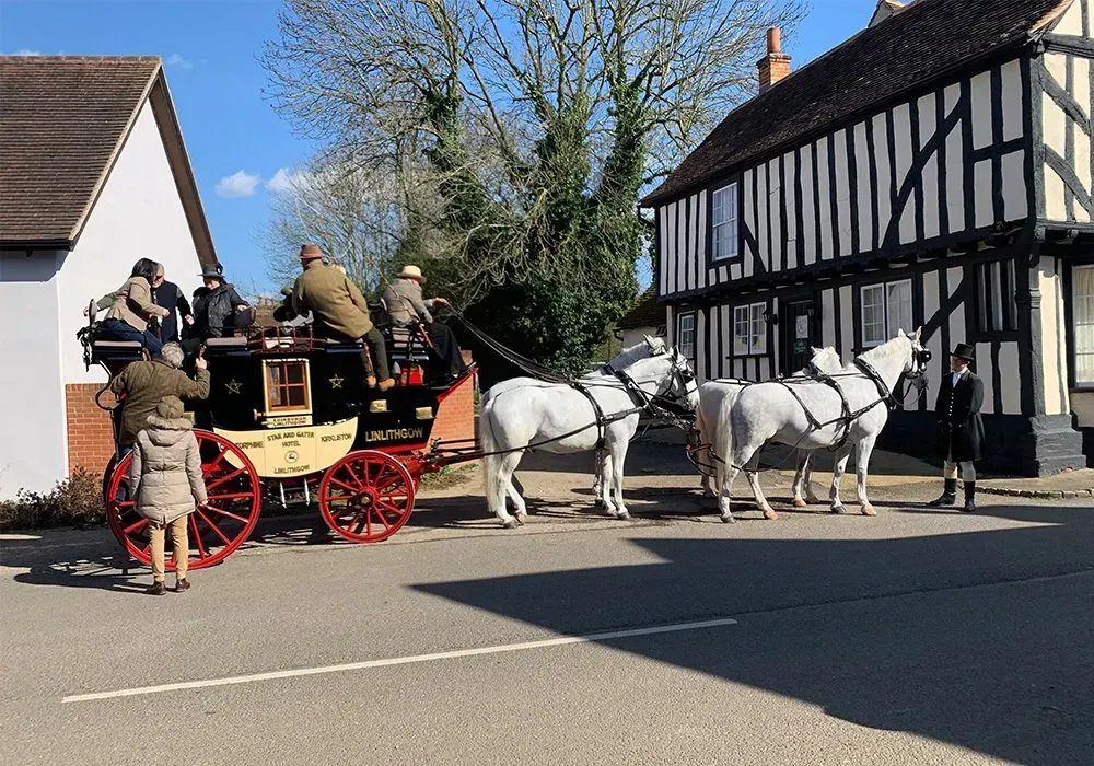 A horse drawn carriage is parked in front of a building