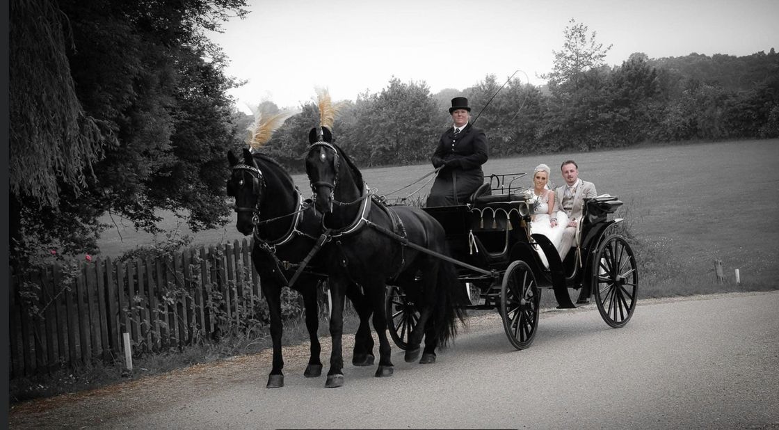 A black and white photo of a horse drawn carriage