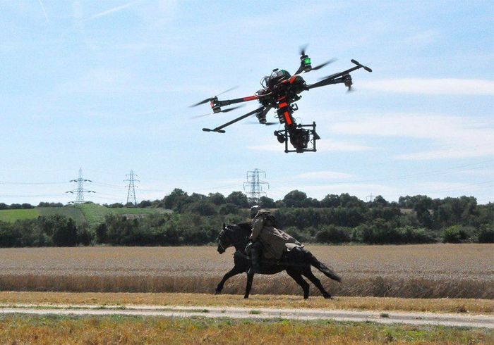 A drone is flying over a horse in a field
