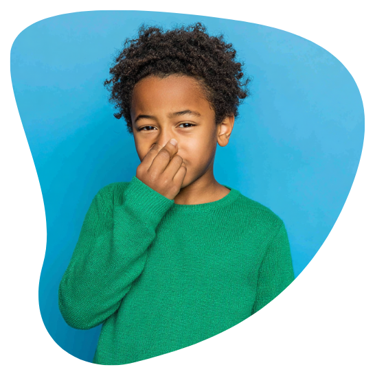 Boy in green sweater holding his nose with a disgusted expression, blue background.