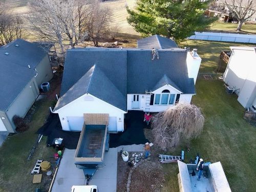 An aerial view of a white house with a gray roof