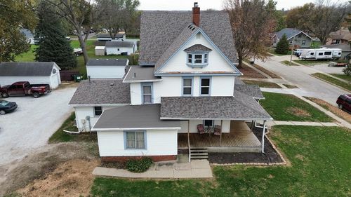 An aerial view of a white house with a gray roof