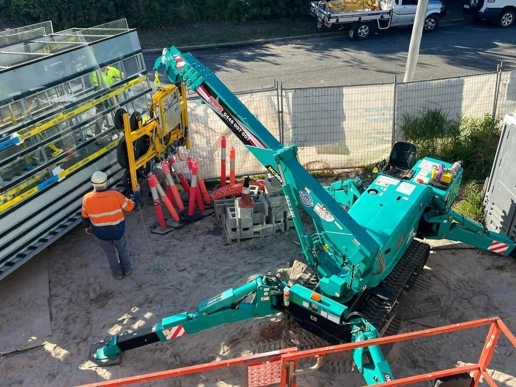 Man Next To A Blue Crane Unloading The Glass In The Truck — SC Glass & Aluminium in Yandina, QLD