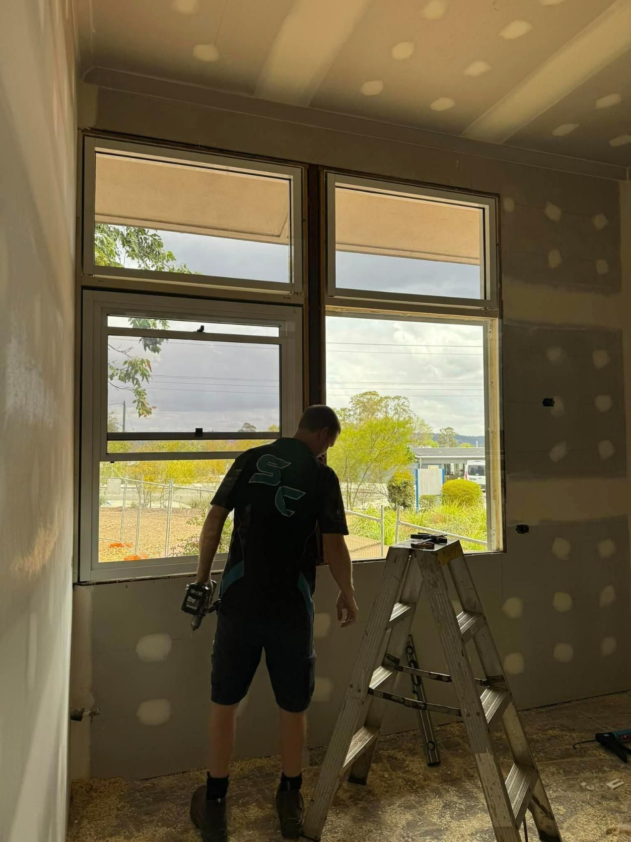 Man Installing A New Window — SC Glass & Aluminium in Yandina, QLD