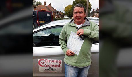 a man holding the driving school certificate
