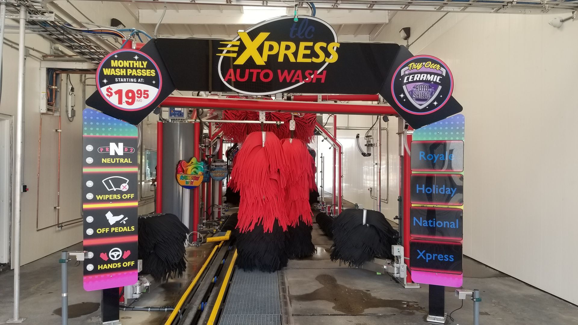 Car wash with red brushes, a conveyor belt, and price sign for $19.95.