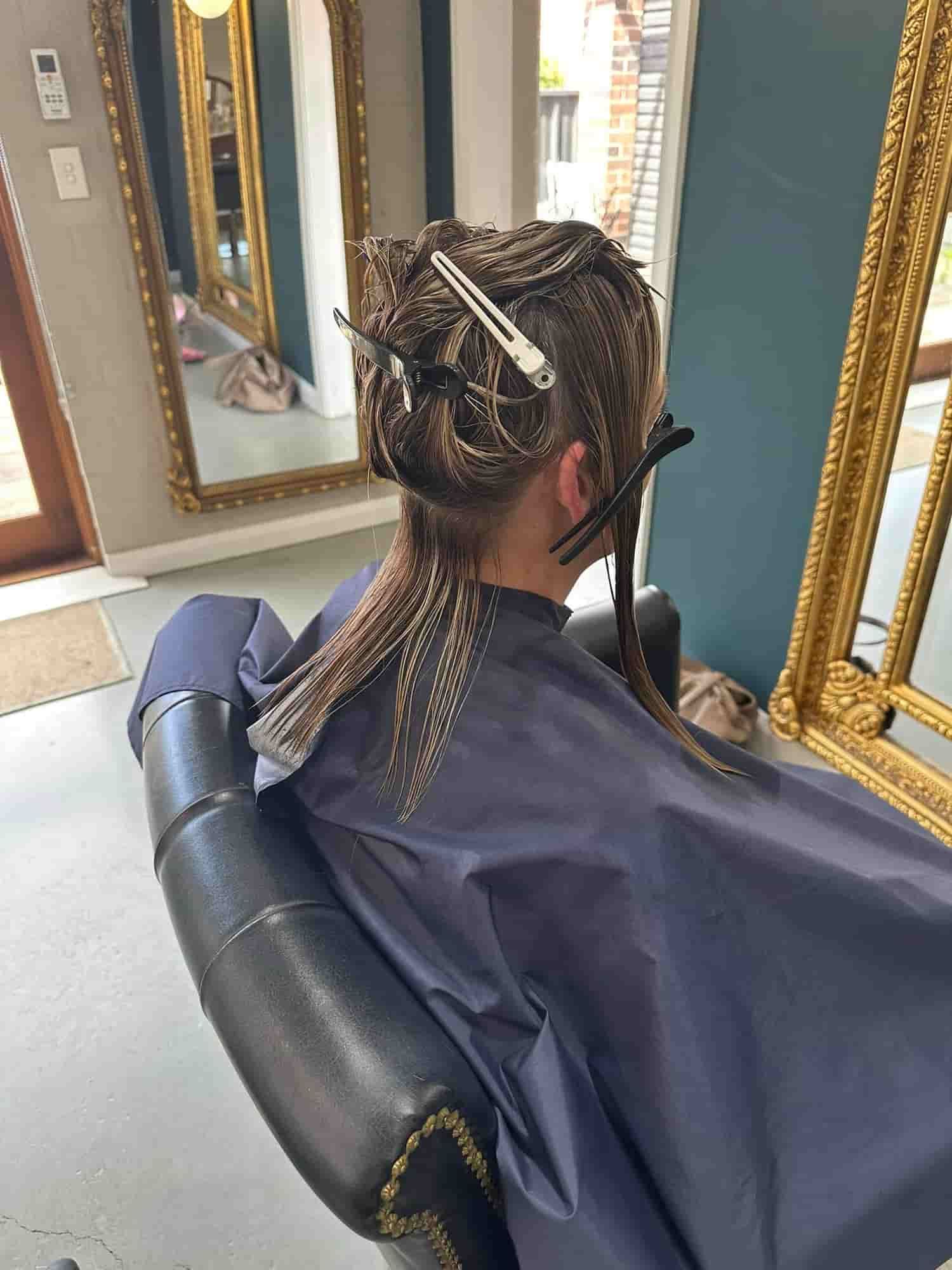 A Woman Is Getting Her Hair Cut In A Salon — Minnie & Lucille Hairdressing In Armidale, NSW