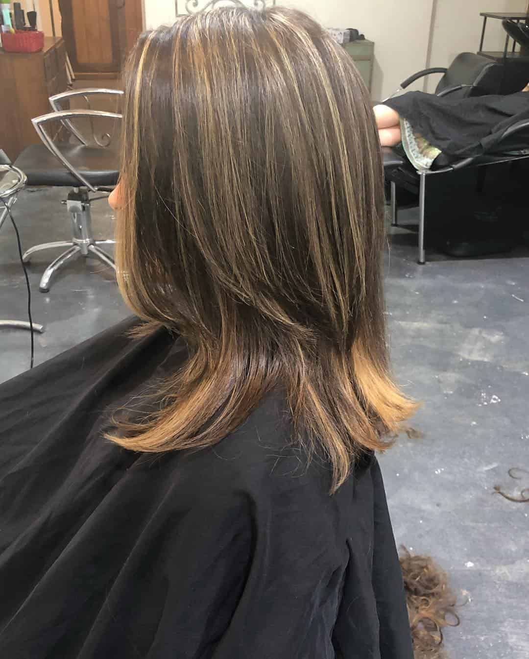 A Woman Is Getting Her Hair Cut In A Salon — Minnie & Lucille Hairdressing In Armidale, NSW