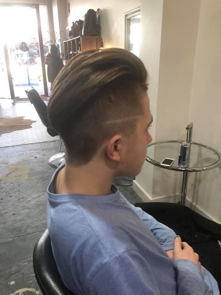 A Young Man Is Sitting In A Chair In A Salon With His Hair Cut — Minnie & Lucille Hairdressing In Armidale, NSW