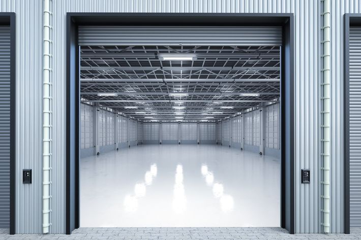 an empty warehouse with a large garage door open .