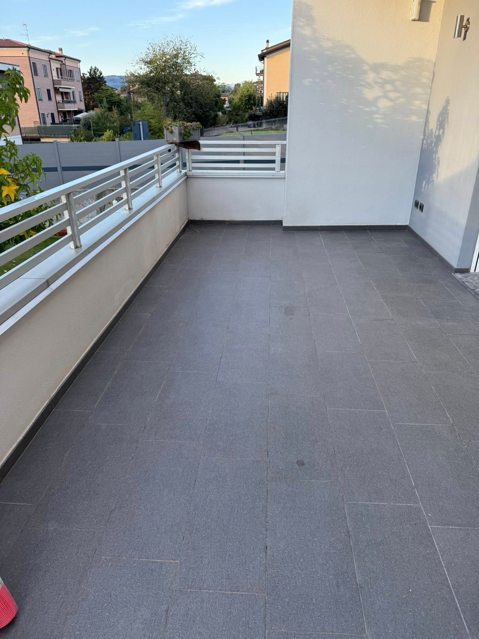 Studio di tatuaggi con un grande murale di David, illuminato da luci calde. Una sedia sterile è in primo piano.